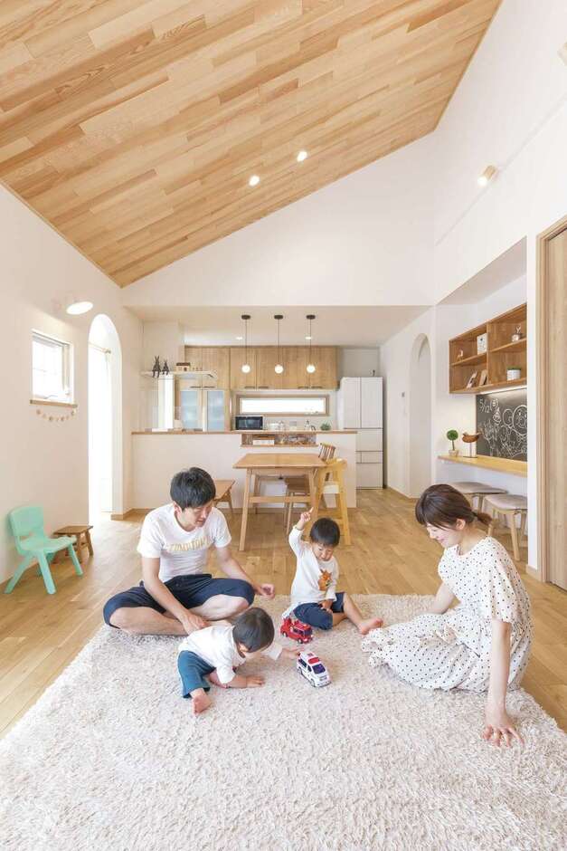 平屋のメリットを活かした勾配天井は木でぬくもり感をプラス。キッチンだけ天井を下げて変化をつけた