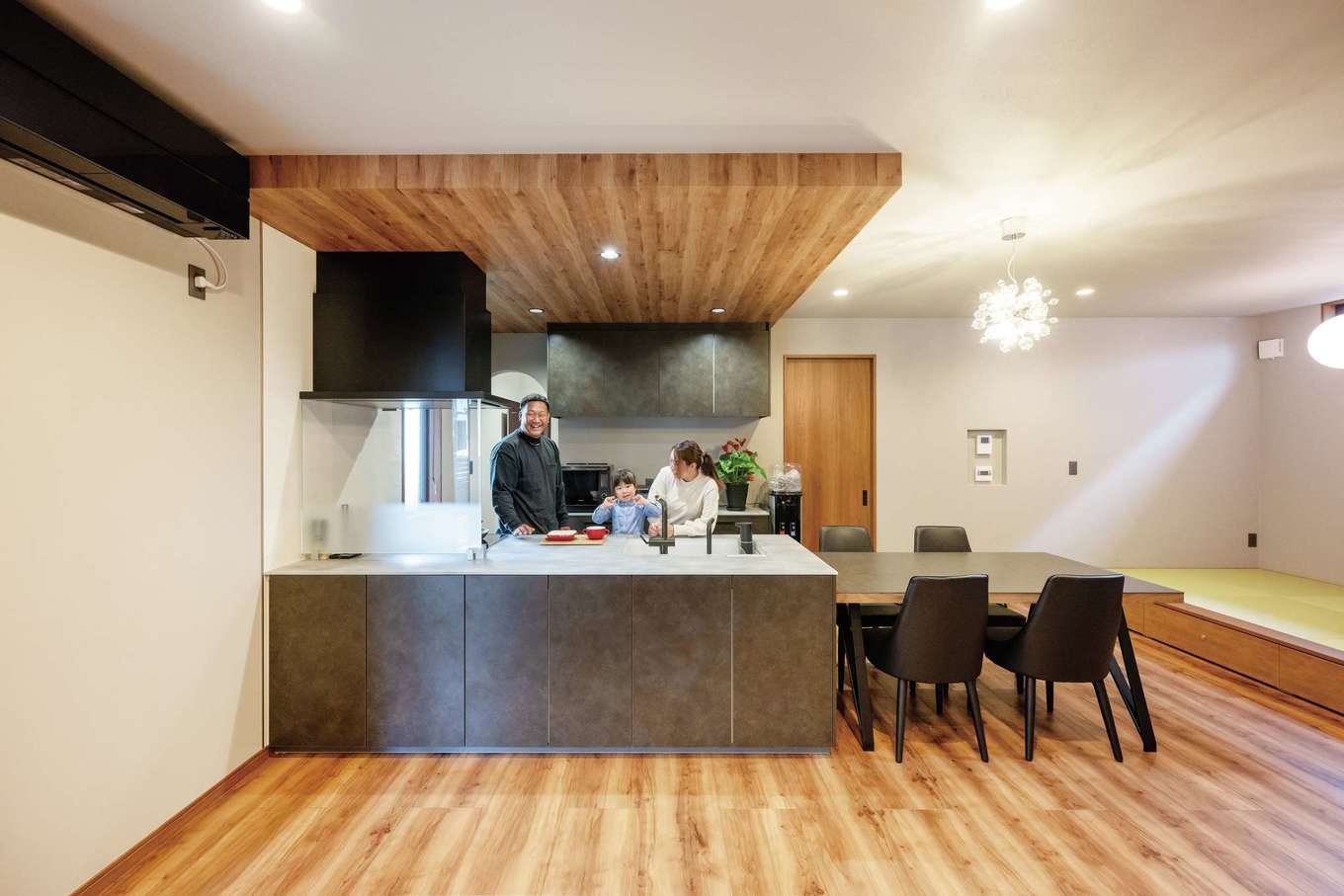 irohaco（アヴァンス）【デザイン住宅、子育て、間取り】小上がりの畳コーナーと合わせると24畳もの大空間LDK。存在感のあるキッチンは美しいクリスタルトップに心躍るTOTOの「ザ・クラッソ」。フローリングと同じ色合いの下がり天井で空間にアクセントを