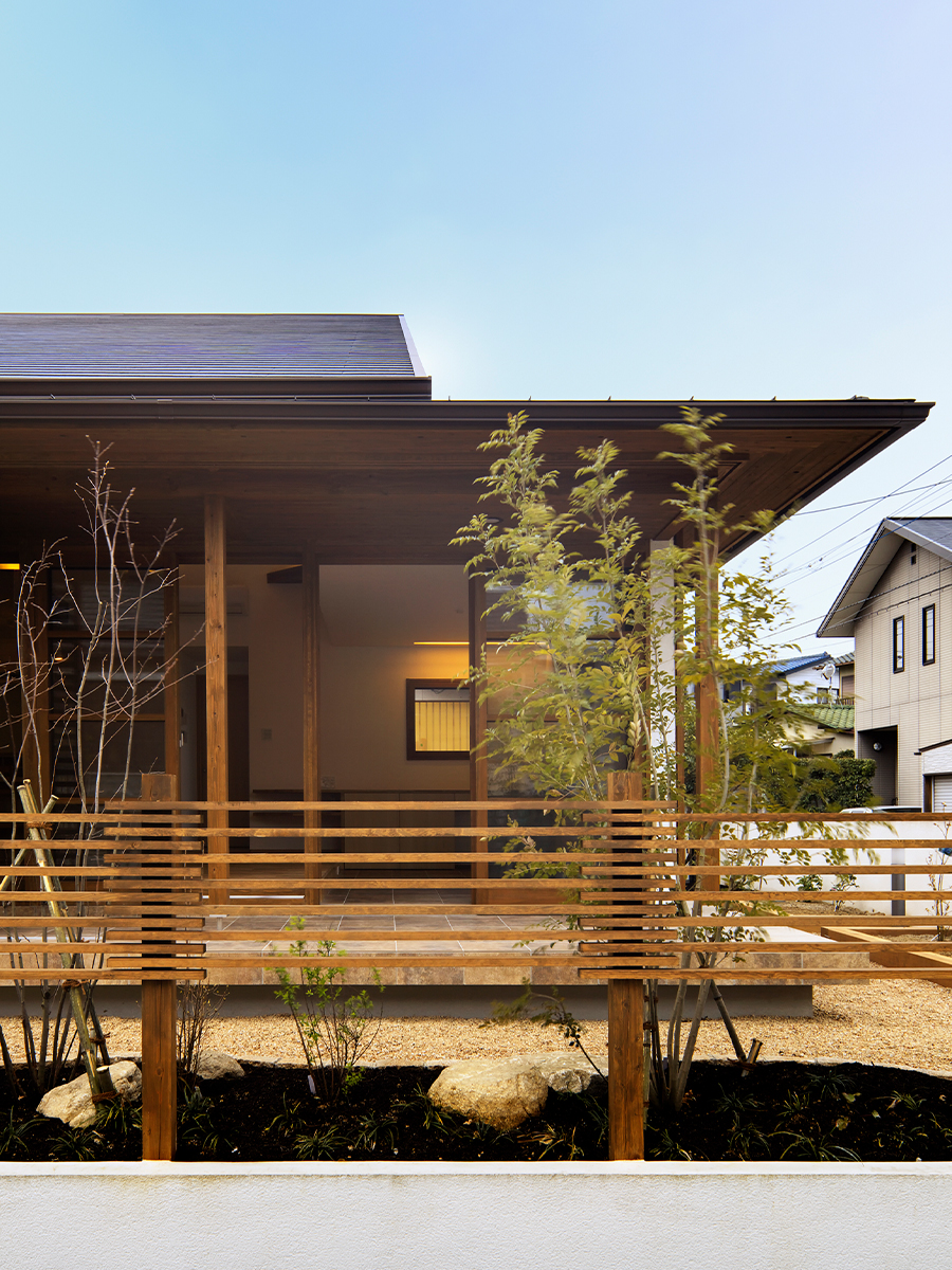 斉藤工務店｜木材をふんだんに使用した、自然と調和した住宅の外観。格子状のフェンスと植栽が、モダンで温かみのある印象を与えている。