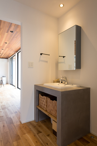 キッチンと同じ素材で造作した手洗いコーナー。玄関から近い場所にあるので、外から帰ってすぐ手を洗う習慣が自然に身につき、感染対策にもなる。脱衣室と離したことで、誰かが入浴中でも自由に手を洗うことができる