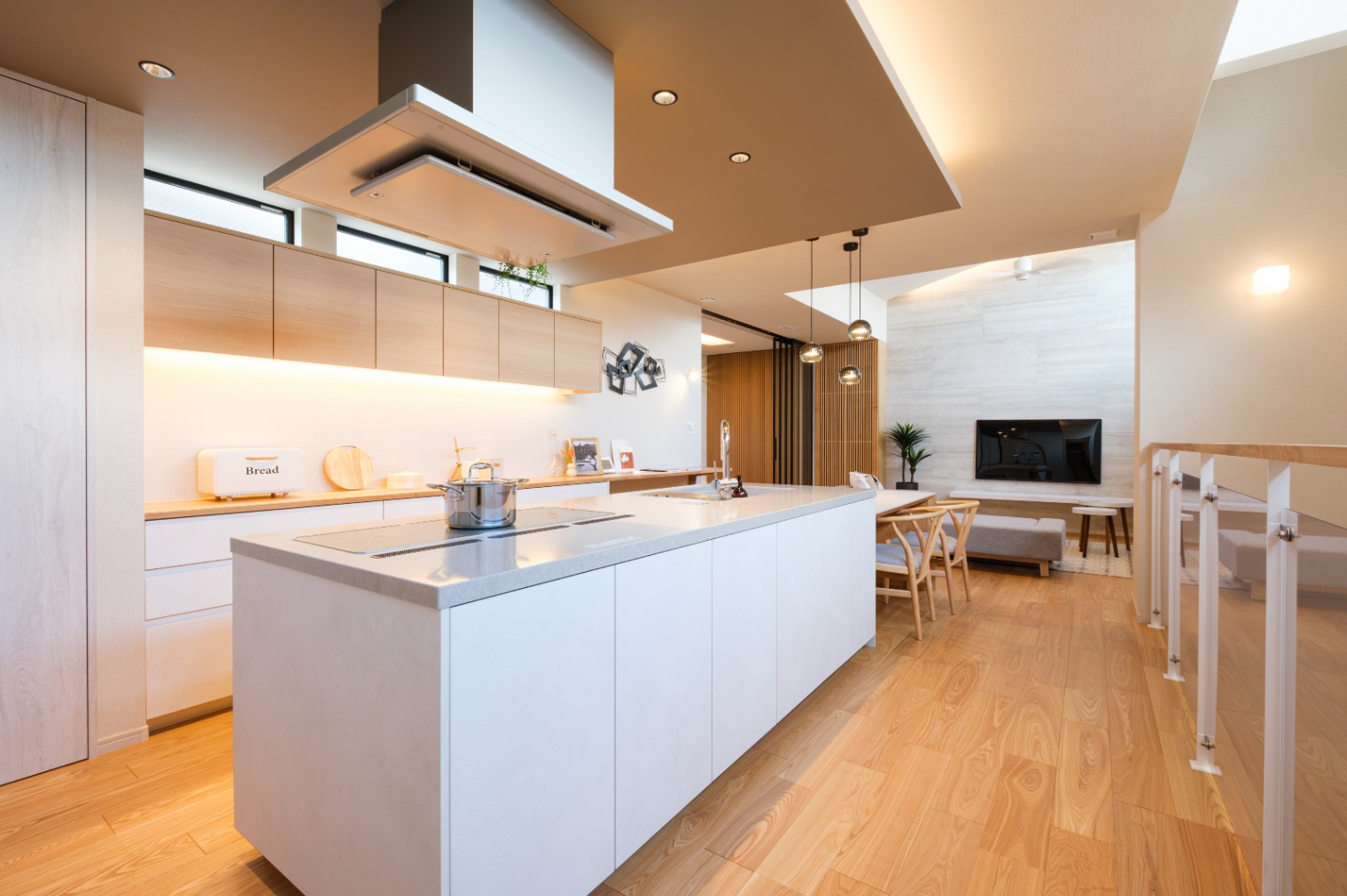 新栄建設｜開放感あふれるアイランドキッチン。3口横並びのIHやフロントオープン食洗器も搭載。共働き夫婦の日常生活を便利にする。