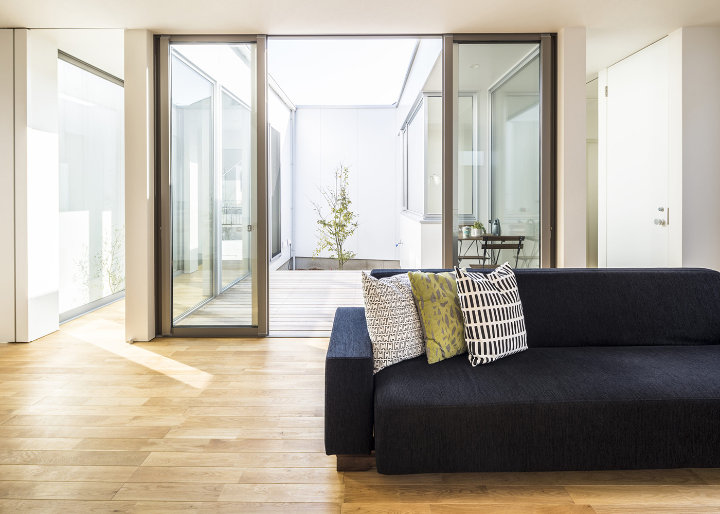 SIMPLE NOTE 豊川スタジオ【夫婦で暮らす、間取り、平屋】両隣に建物がある敷地でも、中庭から全居室に光が届くので、こんなに明るい空間に。外からは見えないウッドデッキで、毎週のように友達家族を呼んでのびのびとBBQを楽しんでいるという