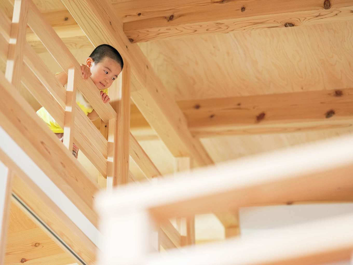 アクトホーム【自然素材、省エネ、間取り】16畳もの小屋裏には本棚も備えられ、収納以外の役割も増えていきそうな予感。大工の手仕事により仕上げられた手すりは角が取られ、小さな手にもやさしくなじむ