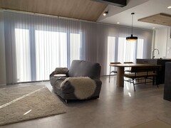 広々としたLDKの空間。大きな窓から自然光が差し込み、明るく開放感のある仕上がりで、家族が集まるリラックスした雰囲気が漂う。