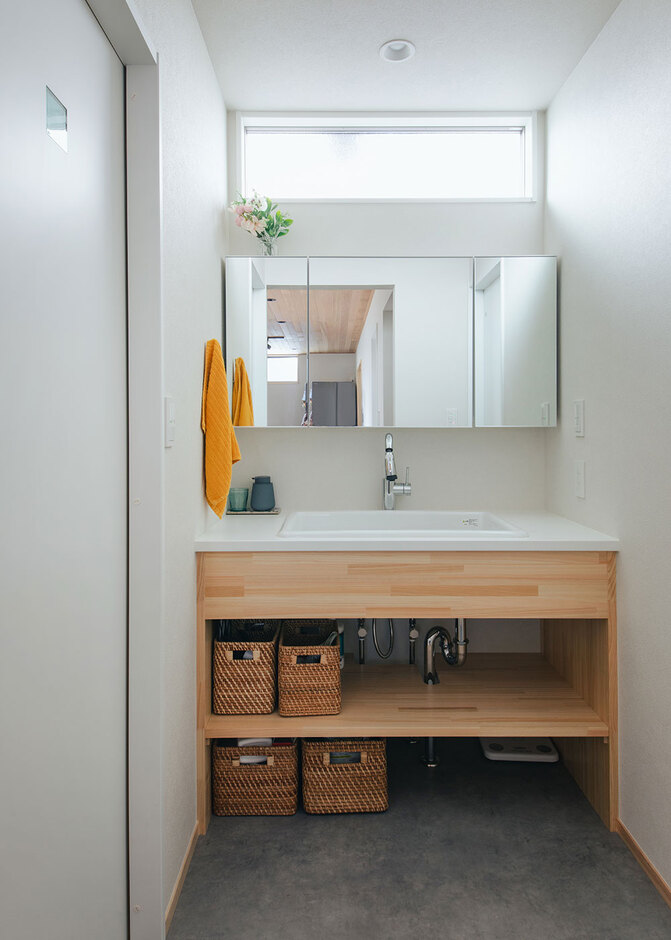 造作の洗面台には大きなボウルと鏡を採用