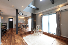 開放感あふれるLDK空間。高い天井と大きな窓から自然光が注ぎ込み、明るく心地よい雰囲気を演出している。モダンなインテリアが印象的。