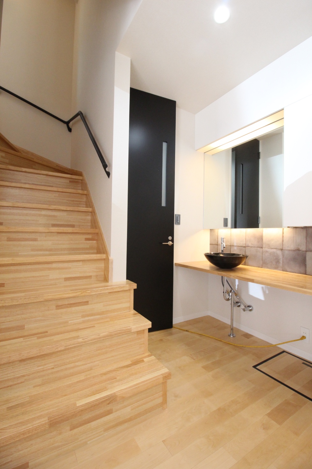 小野田産業～designers house project～｜タイルと照明でホテルライクな洗面スペース。明るい照明と工夫されたデザインが一体となり、モダンな印象を与えている。