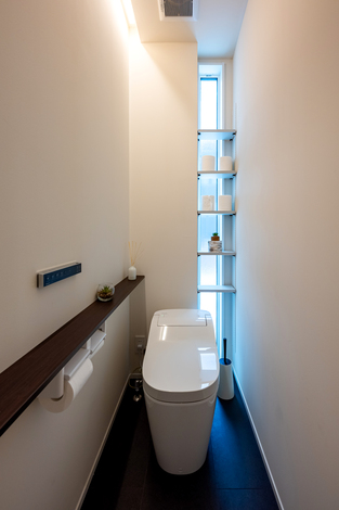 コンパクトな空間にスリムなデザインのトイレを設置。壁面収納と自然光が心地よい明るさをもたらし、清潔感あふれる空間となっている。