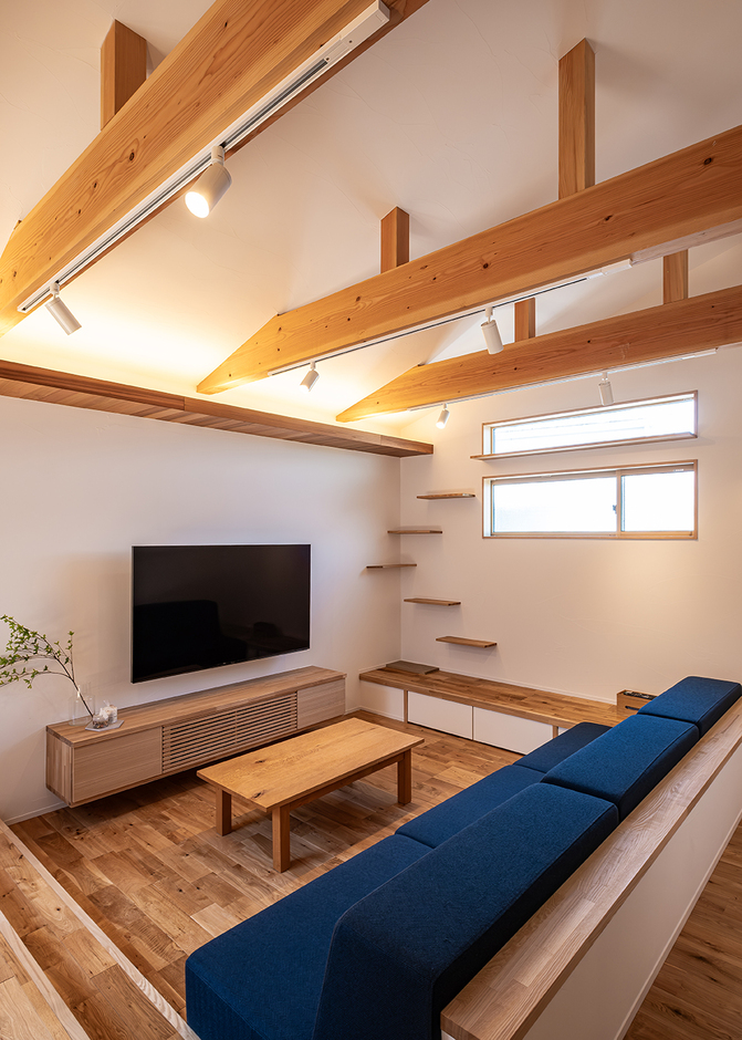 ダウンリビングの上部の勾配天井が開放感をアップ。リビングの壁には愛猫も楽しく遊べるキャットウォークを設置した