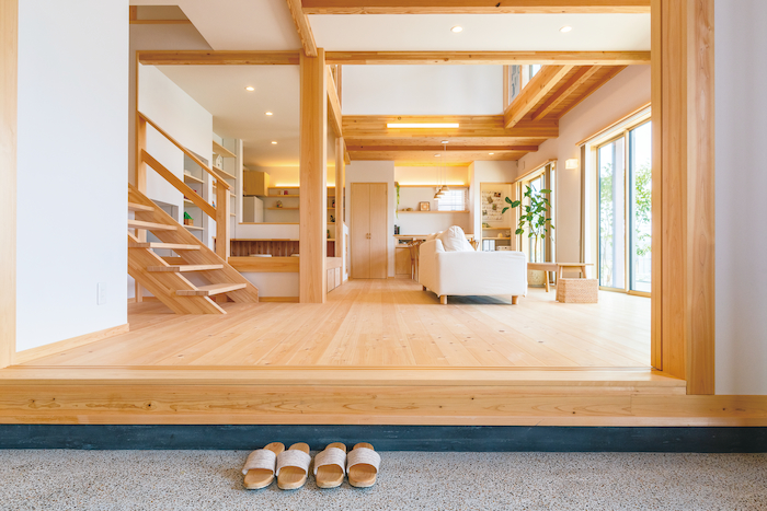 福工房【豊川市篠束町仲堀65-1・モデルハウス】玄関ドアを開けると土間とLDK、さらに吹き抜けを通じて2階までが一体となった大らかな空間が広がる。キッチンのママに「いってきます」や「ただいま」の声が届く