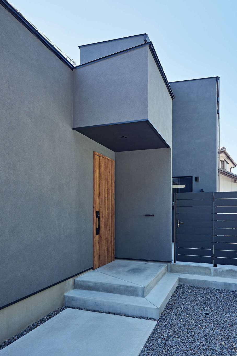 平屋建築ブルーハウス【デザイン住宅、建築家、平屋】塗り壁に木の扉がマッチした玄関ポーチ