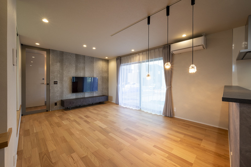 トキワハウス デザイン アンド ビルド（常盤工業）｜広々としたリビングダイニング。大きな窓から自然光が入るため、明るく開放的である。モダンな照明がスタイリッシュな印象を与えている。