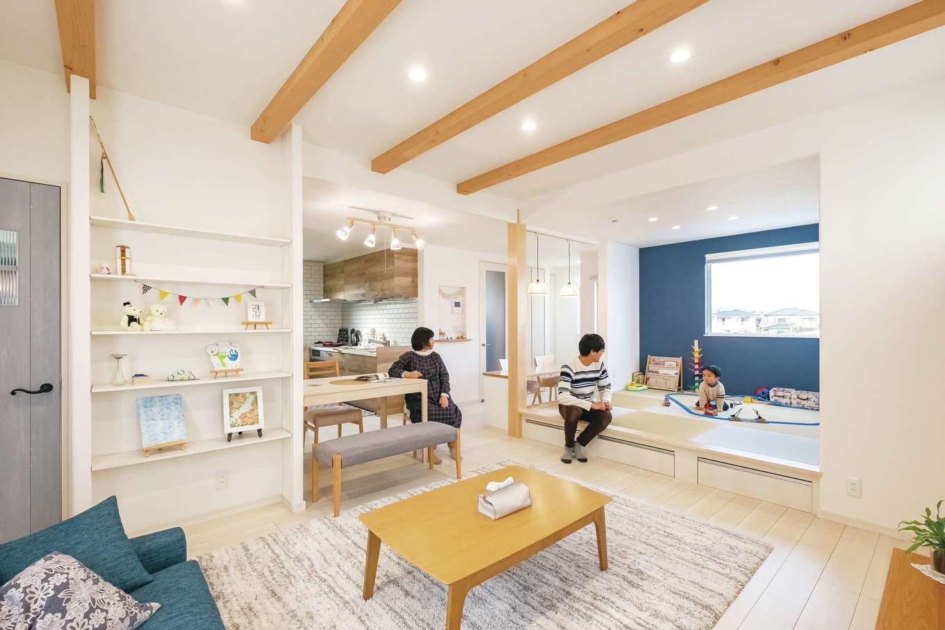 イデキョウホーム【デザイン住宅、省エネ、屋上バルコニー】斜めからの視界が開け、広く見える空間取りを採用。白い床と壁に木の温もりとアクセントカラーのブルーを添え、明るく爽やかな雰囲気に。富士山が望める和室の北側には大きなFIX窓を。毎日見られる場所に家族の写真を飾りたいとリビングの壁一面にディスプレイ棚を造作。UA値0.44と北海道レベルの高断熱と特許取得の全館空調システムが、365日室温20℃台をキープ。エアコン1台で、広いLDKをはじめ、家のどこでも快適に過ごせる