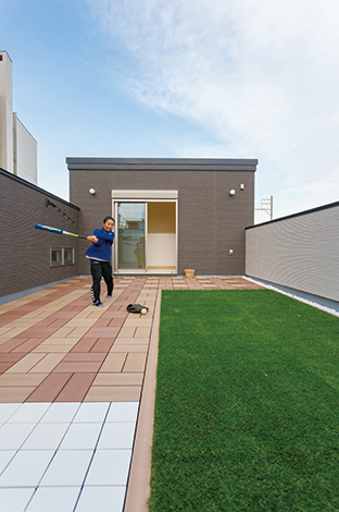 コットンハウス【デザイン住宅、狭小住宅、屋上バルコニー】すぐ間近に赤電が走るスカイバルコニーは、都心のエアポケットのよう。屋上なので、人目を気にせず野球の練習に励んだり、BBQや花火も存分に楽しめる