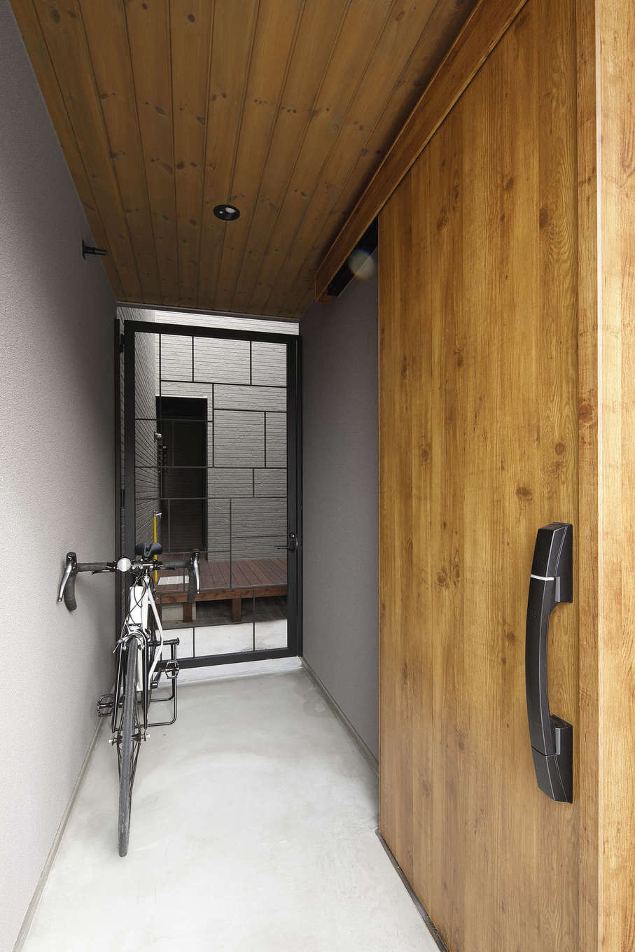 檜建設 エニーホーム【デザイン住宅、趣味、建築家】「本物を使いたい」というWさんの希望で軒天なども無垢の木に。エントランスと中庭の間に設けたアイアンの造作建具にもこだわりが光る