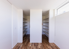 夫婦それぞれ独立のウォークインクローゼットを確保し、各自専用の収納スペースを設けた。ドアを省いてコストをコントロールすると同時に、シンメトリーのデザインが美しい仕上がりとなっっている