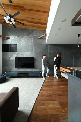 開放感のあるリビングは、シーリングファンが設置されており、空気の循環を促進する設計がされている。木材が多用され、温かみが感じられる。