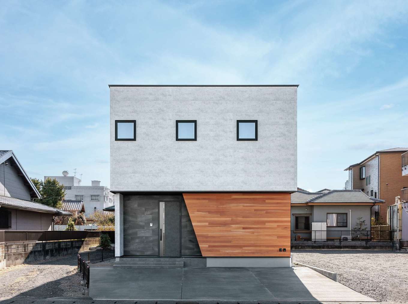 tact design firm【デザイン住宅、省エネ、間取り】サイディング、タイル、マホガニーという異素材MIXで美しく仕上げた外観。交通量の多い北面道路側は窓を少なくして、プライバシーを確保した