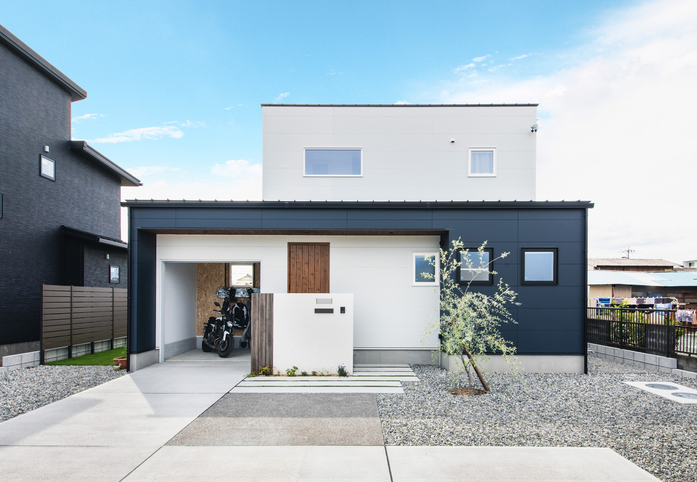 SEIEN ARCHITECT【省エネ、建築家、ガレージ】ツートーンでアクセントをつけたバイクガレージと一体型の2階建て。ガレージの奥には中庭がある