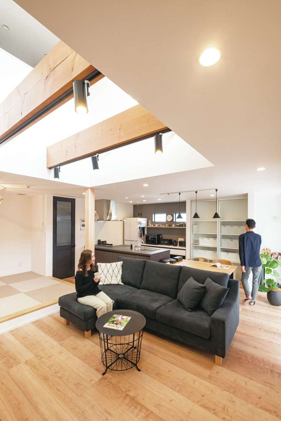 イデキョウホーム【デザイン住宅、省エネ、インテリア】吹抜けの開放感が気持ちいいLDK。視界がタテ・ヨコに広がっていくので、実面積よりも広く感じられる。ソファに座ってウッドデッキ、庭を眺めるのが夫婦にとって至福のひととき。全館空調と吹抜けとの相性も抜群で、家庭用のエアコン1台で家中隅々まで温度差がなく快適に過ごせる