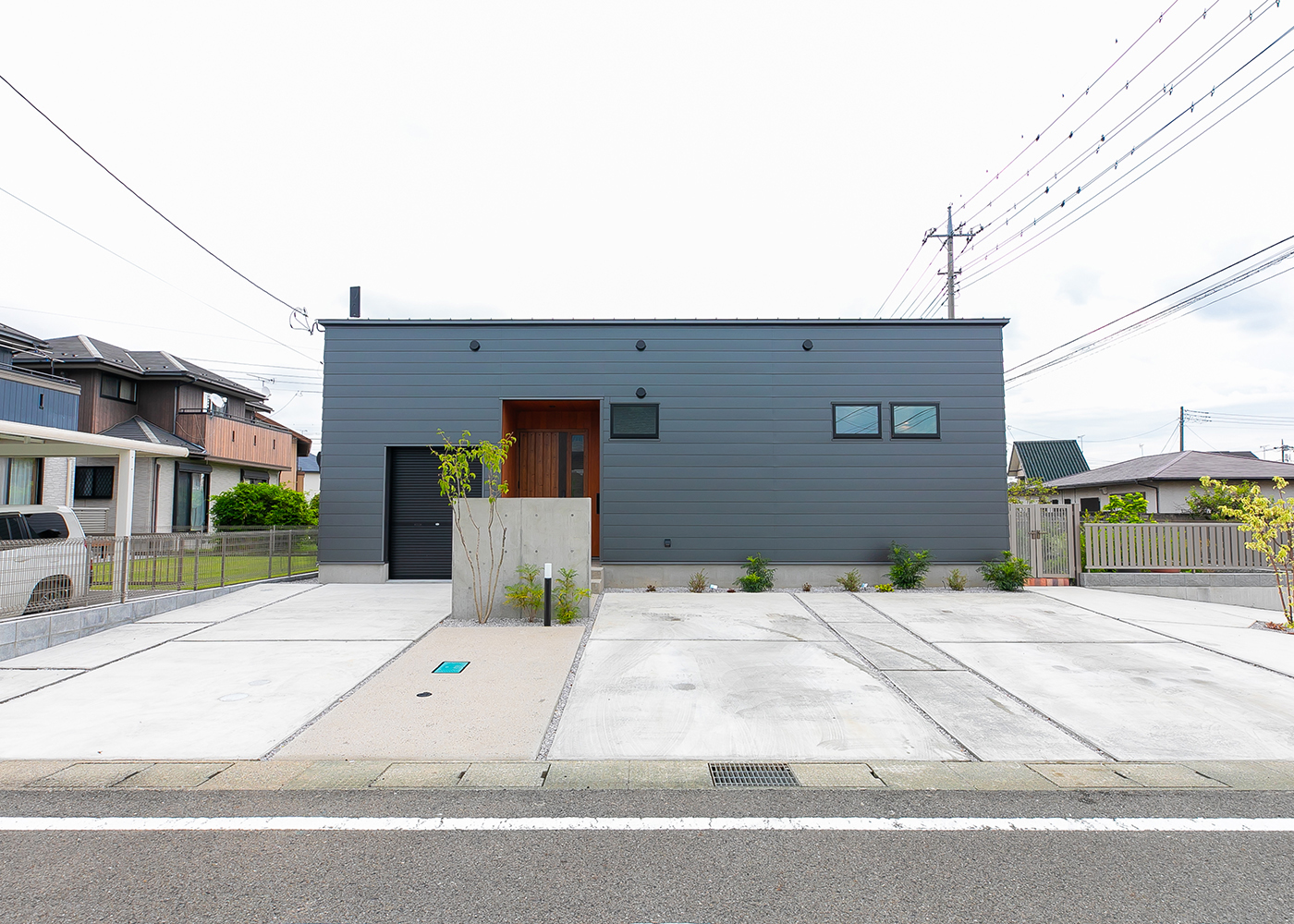 タツホーム・竜建｜直線的なデザインが特徴のシンプルな平屋の外観。広々とした駐車スペースとモダンな外観が調和している。