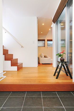 -delphi- デルフィ（藤井建築事務所） 【デザイン住宅、間取り、建築家】手すり壁のない階段、高さのあるドア、ワイド幅の窓と、玄関にも広さと明るさをもたらすための工夫。左手には防災用品なども収納する広々としたシューズクローク