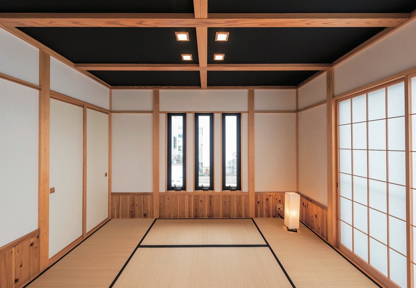 ハウテックス【1000万円台、自然素材、平屋】16.5畳のLDKと接する6畳の和室。黒い天井と照明が個性的