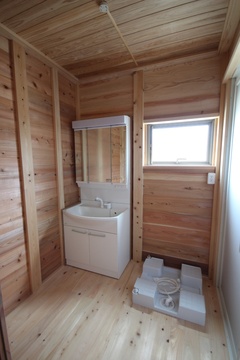 木目の柔らかな風合いが特徴の洗面スペース。自然光が差し込む窓があり、明るく開放的な空間で、爽やかな朝の身支度をサポートする。