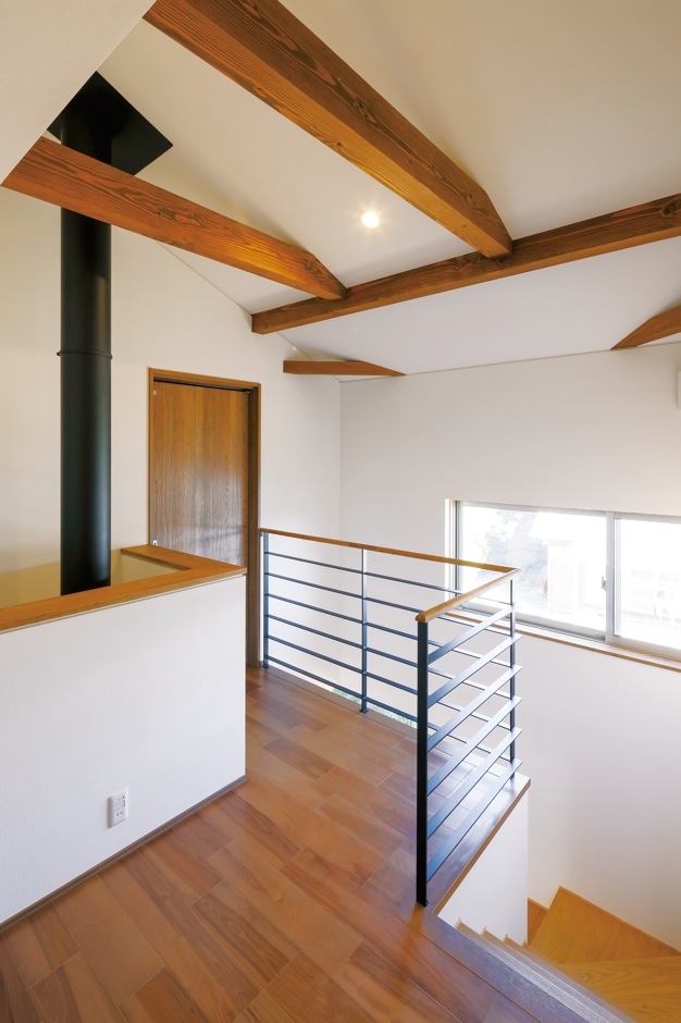 神谷綜合建設 カミヤの家【自然素材、間取り、インテリア】アイアンの手すりと梁、薪ストーブの煙突がマッチした2階のホー ル。何気ない空間にもセンスの良さが感じられる