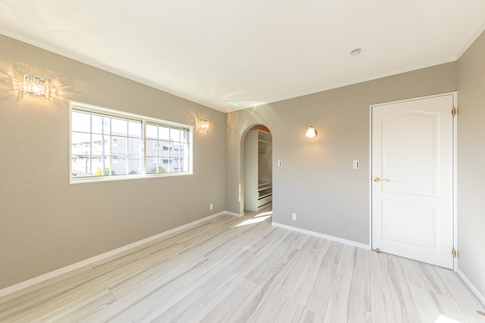 明るい居室で、アーチ形の通路と窓から差し込む自然光が魅力的である。シンプルながらも優雅な空間で、幅広い用途に利用可能。