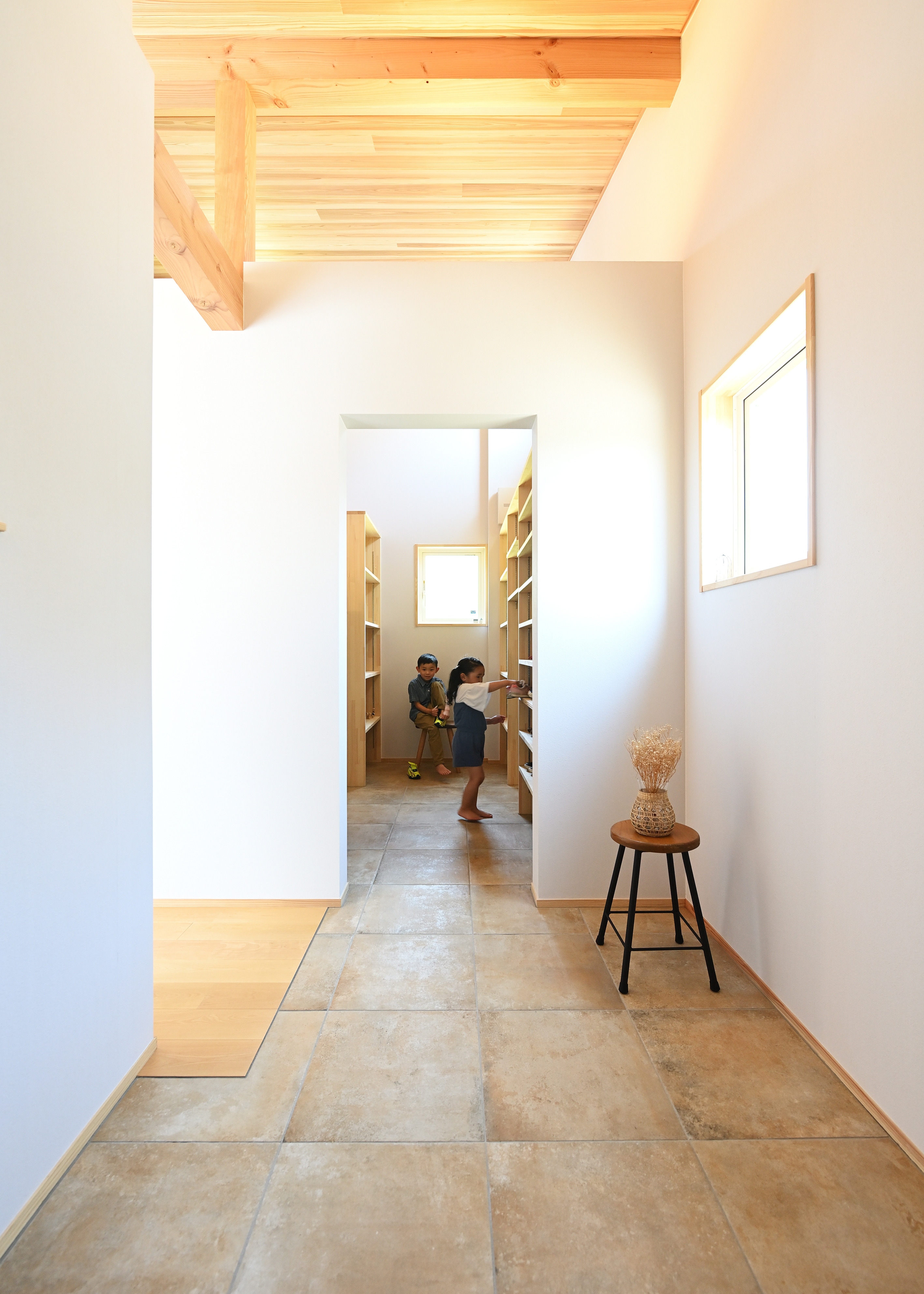 KANAZAWA STYLE/金澤建築【省エネ、間取り、平屋】玄関ホールから段差なしでフラットにつながる土間収納。造作の収納棚は、靴だけでなくコートや傘をかけるスペースもある