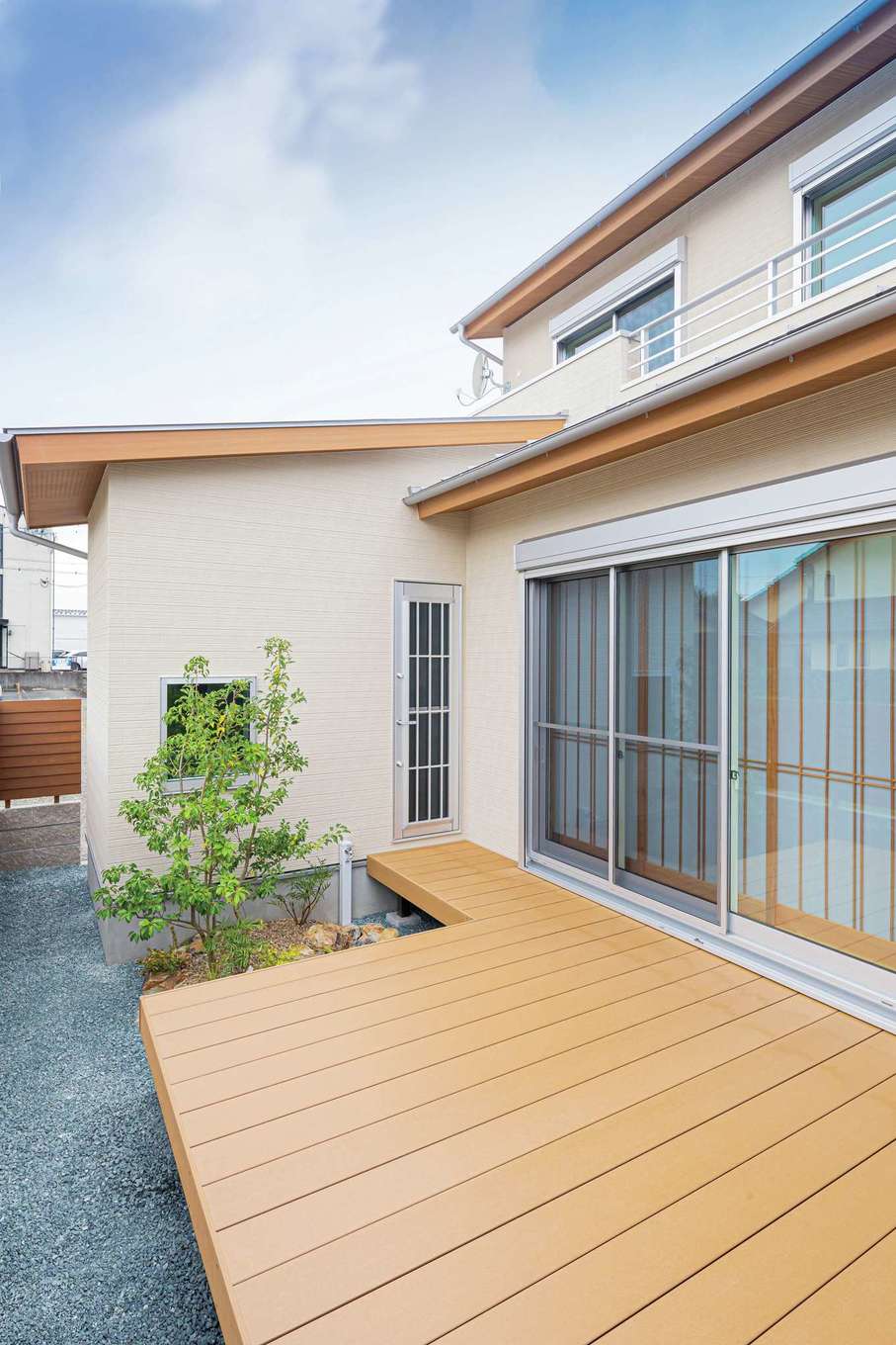 近藤建設工業【収納力、自然素材、間取り】リビングからも洗面所からも出入り可能なウッドデッキ。木の奥にはバスルームの窓があり、景色を眺めながらバスタイムを楽しめる
