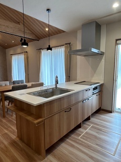 モダンでスタイリッシュなアイランドキッチン。広々とした調理スペースとシンプルなデザインが魅力的。ダイニングとの一体感も演出している。  