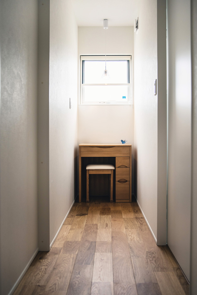 SEIEN ARCHITECT【省エネ、建築家、ガレージ】１階の洗面スペースとトイレの間に配置したのは、奥さまがお母さまから譲り受けた小机。マンション時代にも使っていたので、これからもずっと使いたいとの要望から、あらかじめ設計段階で置く場所を確保した。窓から自然光が入り、奥さまが毎朝ドレッサー代わりに利用