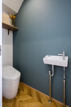 階段下に設けたタンクレストイレ。
背面には、カウンターを作り物置として活用。