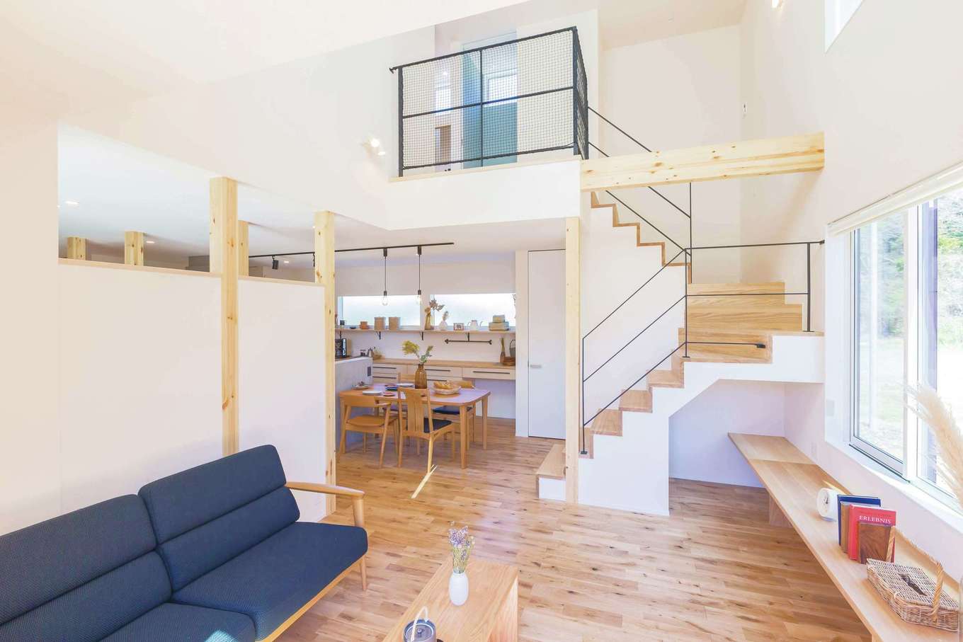 ARRCH アーチ【デザイン住宅、間取り、建築家】吹抜けがダイナミックな開放感をもたらすリビング。南面から心地よい光が室内全体に注ぐ。キッチンを中心にランドリールームや収納、2階への動線を配置し、家事動線をショートカットした