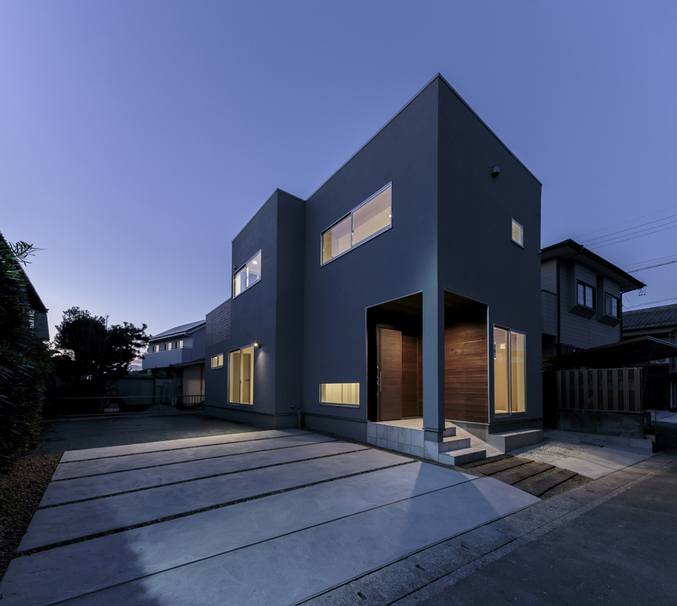ARRCH アーチ【デザイン住宅、趣味、建築家】東西に細長いフォルムのシンプル&クールな外観。グレーの塗り壁の風合いが建物の上質感を高めている。玄関脇の部屋がご主人のワークルーム