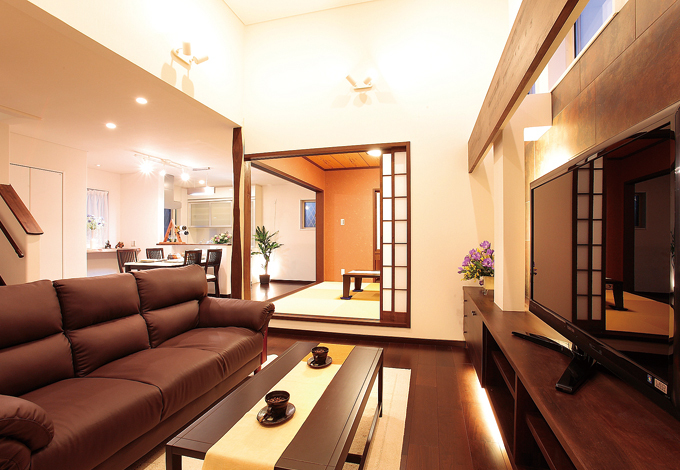 昼も夜も、リゾート感に満たされたリビング.団らんの中心となるリビングは天井高を上げ、広さを演出。焼きタイルを貼ったテレビステーションの前に座れば、リゾートホテルのようなラグジュアリー感に包まれる。計算された照明も夜のくつろぎに一役買っている