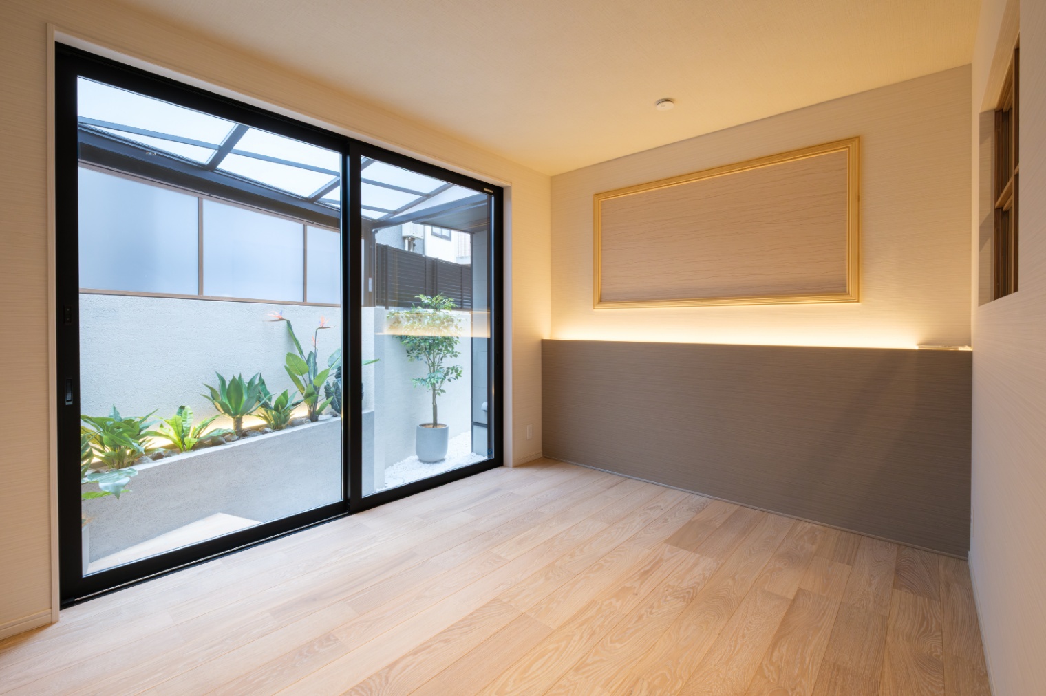 新栄建設｜大きなガラス戸から自然光が差し込む寝室。あえて照明は少なく、就寝前の居心地の良い空間を作り出す。