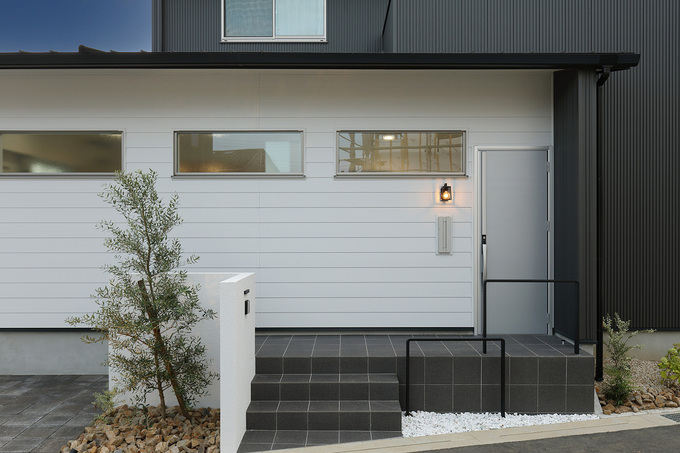 モノクロでシャープにまとまった外観デザイン。夜になると玄関ランプが灯り、アクセントに