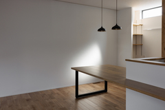 モダンなデザインのダイニングスペース。ナチュラルな木製テーブルとウォールランプがシンプルで落ち着いた雰囲気を演出