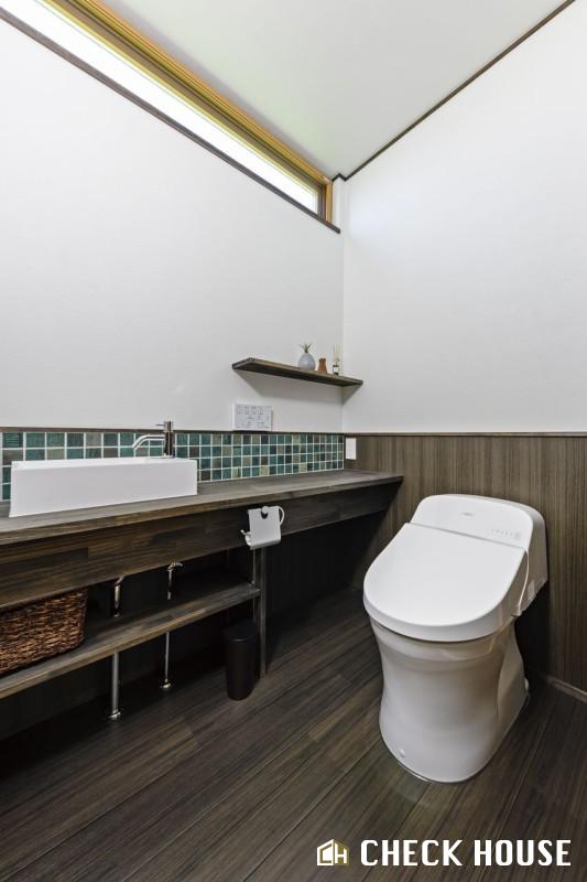 チェックハウス｜広々としたトイレ空間。自然光が差し込み、明るい印象を与えるデザインが施されている