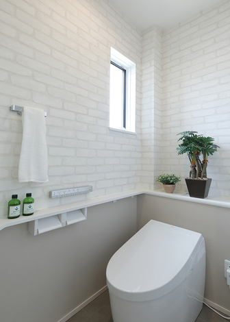 トイレには、小物も飾れる手洗いカウンターを用意。白で統一し、清潔感あふれる空間に