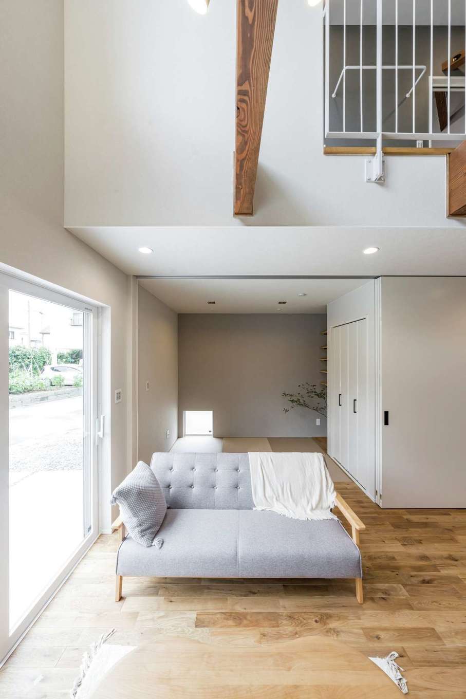 Gate air house/阿部住宅【デザイン住宅、狭小住宅、省エネ】吹抜けを採用したことで、実面積より広く感じられ、十分な明るさも確保した。無垢の床の肌触りが気持ち良くて、普段は家族みんなが裸足で過ごす。ソファの向こう側が畳コーナー