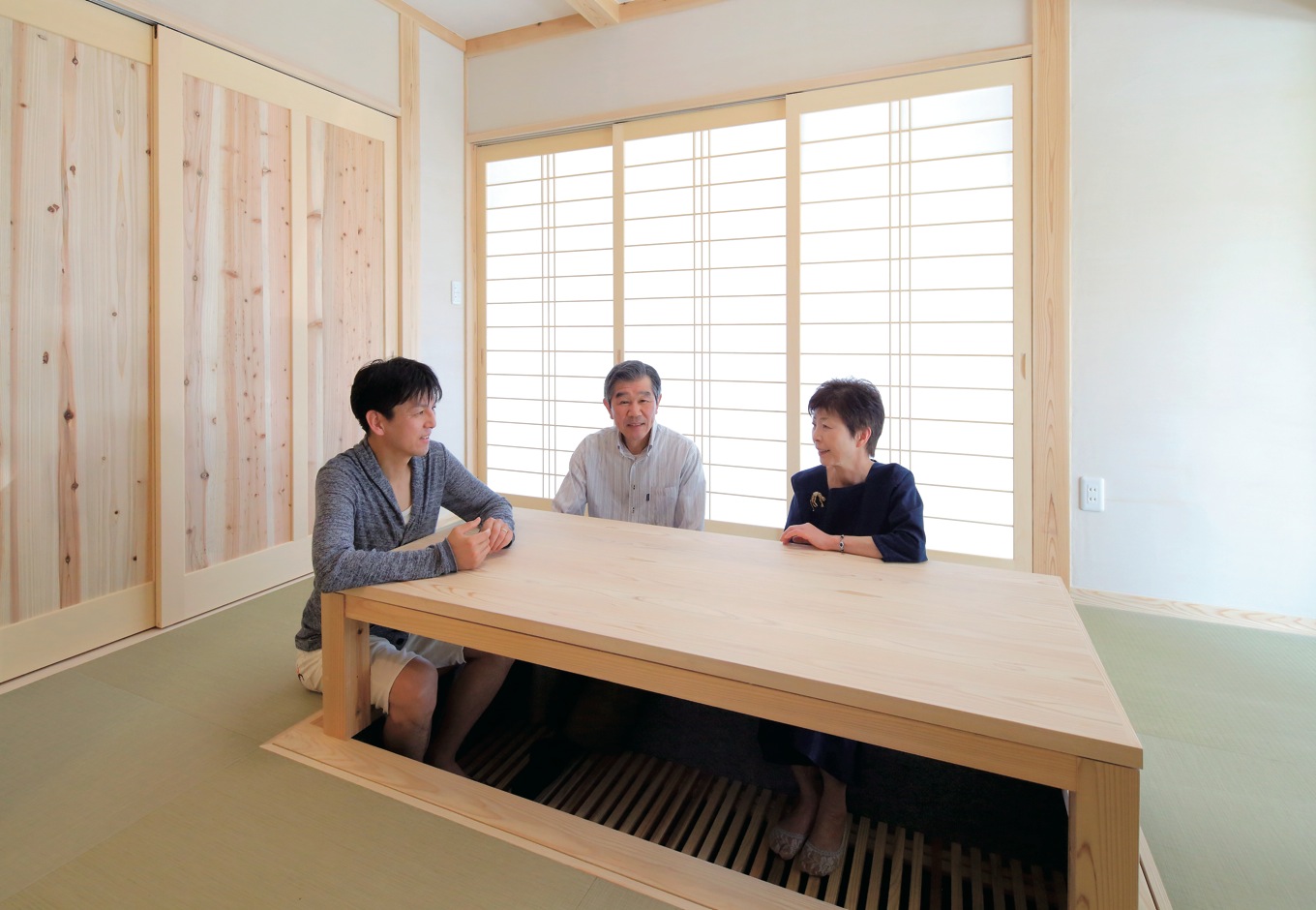 アクトホーム【自然素材、省エネ、間取り】和室は天井を土佐和紙、壁を稚内珪藻土で仕上げ、建具も含め健康に配慮した空間となっている。堀ごたつも同社大工の手技が光る逸品である。この造作座卓は床下に収納することができるので、布団を敷く時にも邪魔にならない