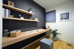 壁に取り付けたシンプルな飾り棚と一体型のデスクが特徴的な書斎。集中しやすい環境を提供し、作業や読書に最適な空間になっている。