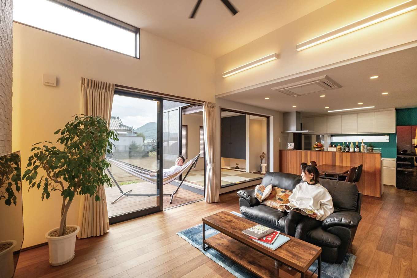 -delphi- デルフィ（藤井建築事務所） 【デザイン住宅、間取り、建築家】天井が上がっており、階段上部の吹き抜けとあわせて高さを感じるLDK。キッチンの壁紙は奥様のチョイス