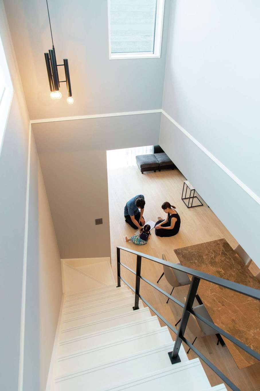 遠州鉄道 遠鉄ホーム【デザイン住宅、狭小住宅、インテリア】リビング階段の吹抜けが開放感をもたらす。天井を飾る海外輸入の照明や、淡いグレーのクロスにセンスが光る