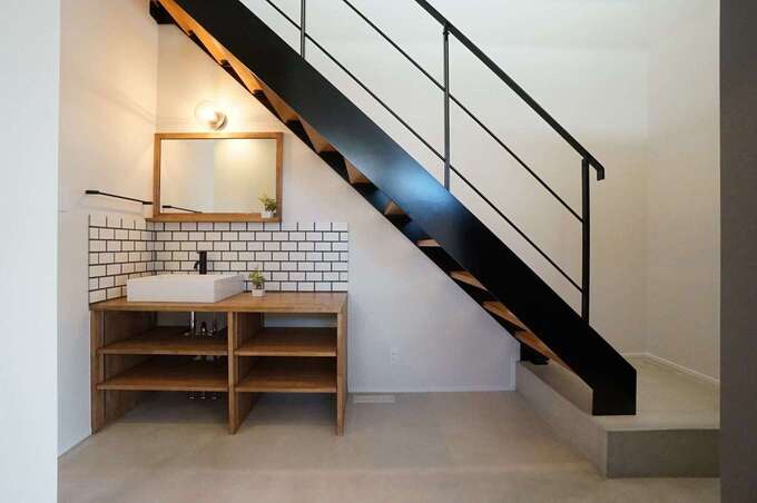 階段がリビング内にあると、子どもが思春期を迎えた頃に鬱陶しく感じるだろうと、玄関ホールに配置。ただし、LDKからも階段が見えるので奥さまも安心できる。階段下のデッドスペースを活かして、手洗いコーナーも設けた