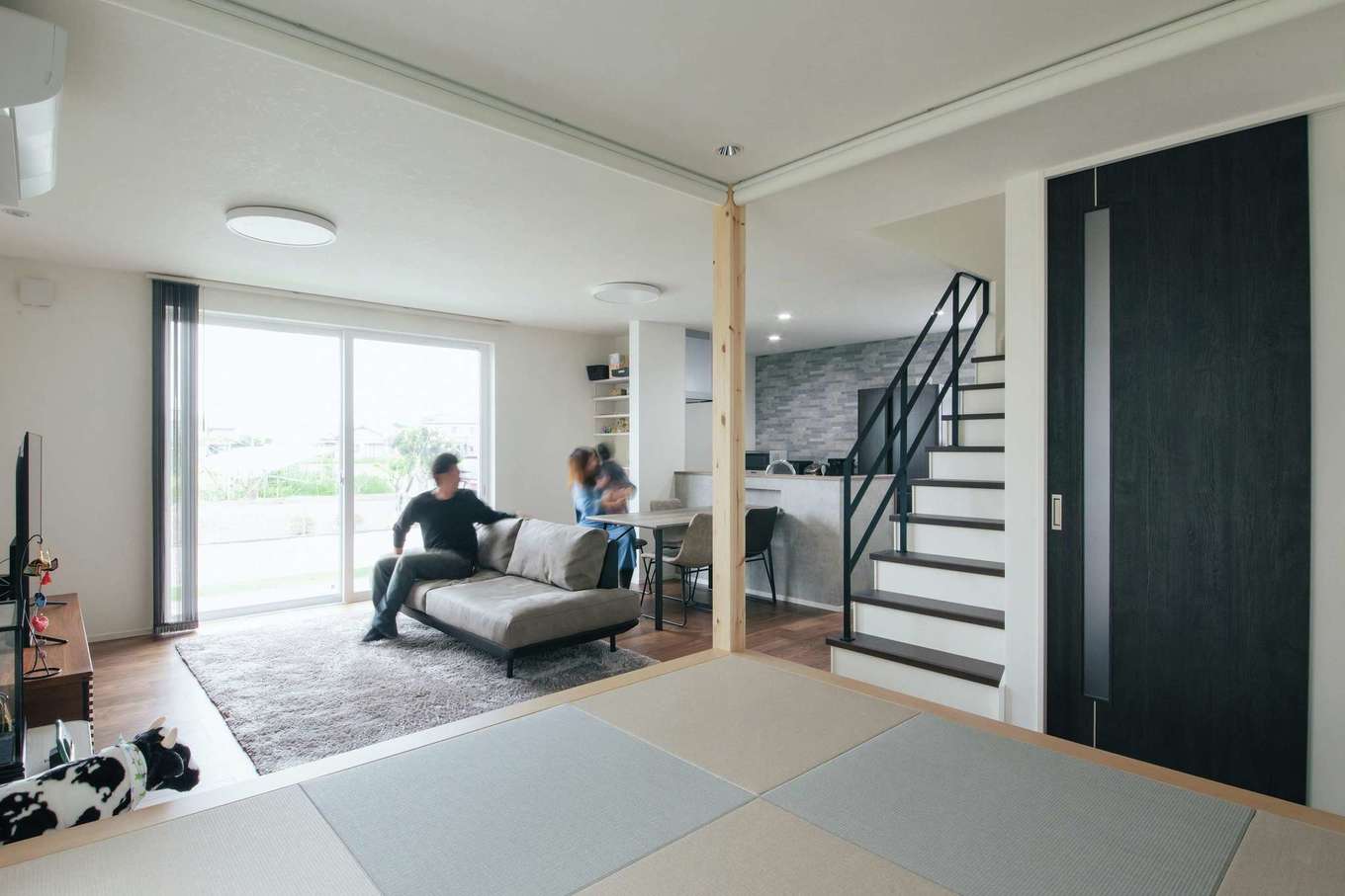 子育て安心住宅 Design Craft Office【デザイン住宅、省エネ、間取り】小上がりから眺めたLDK。造作のアイアン手すりが広い空間のアクセントに